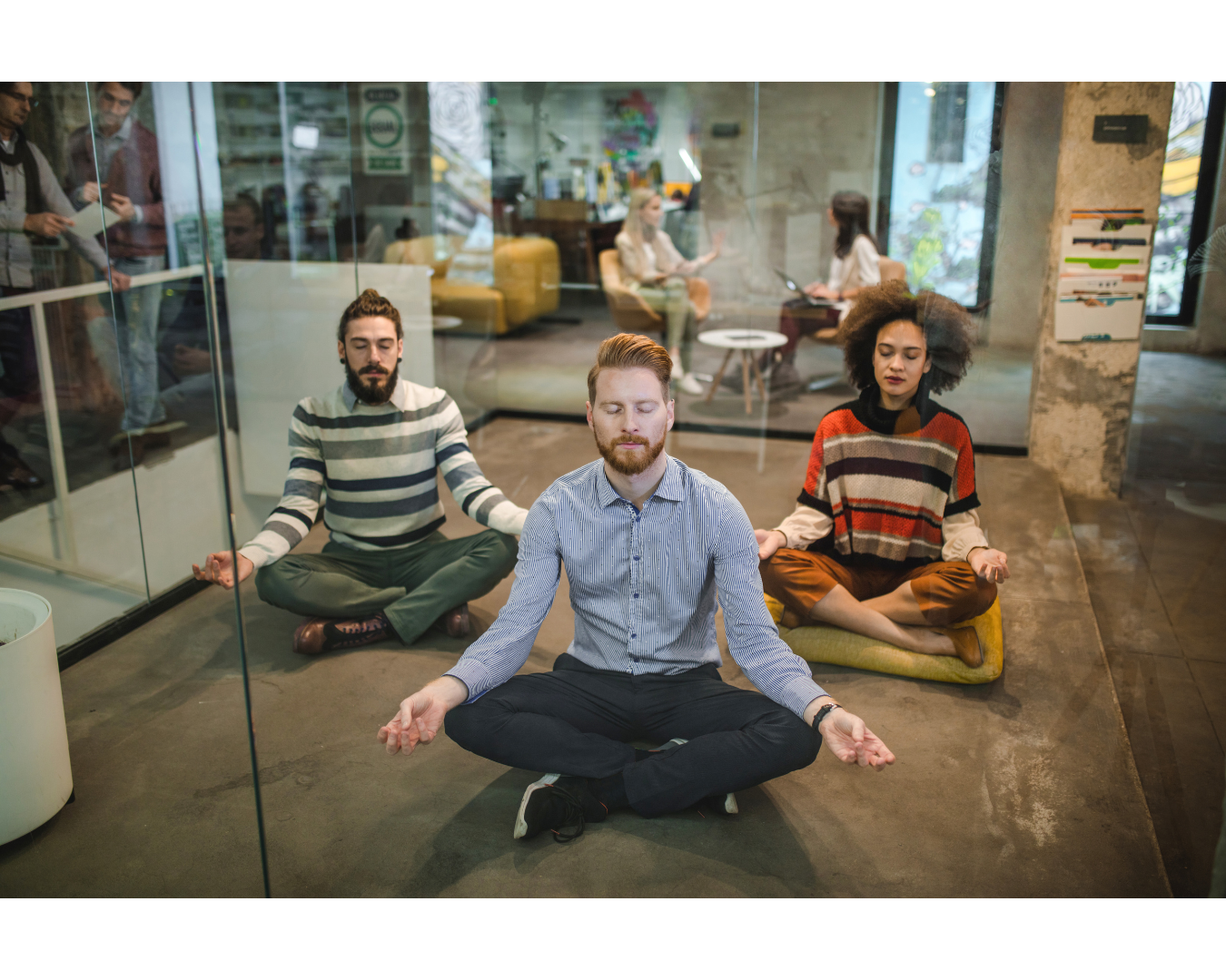 Meditation im Büro 3 Menschen sitzen im Büro im Schneidersitz